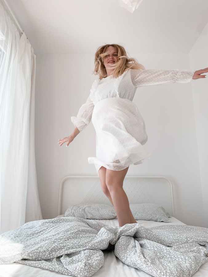 woman standing on bed