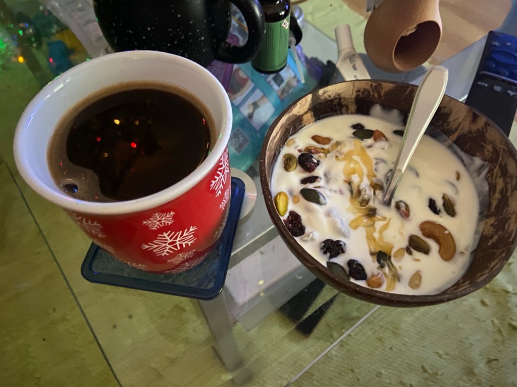 Nervennahrung: Schwarzer Kaffee und Müsli mit Nüssen und getrockneten Cranberries in einer Kokosschale.