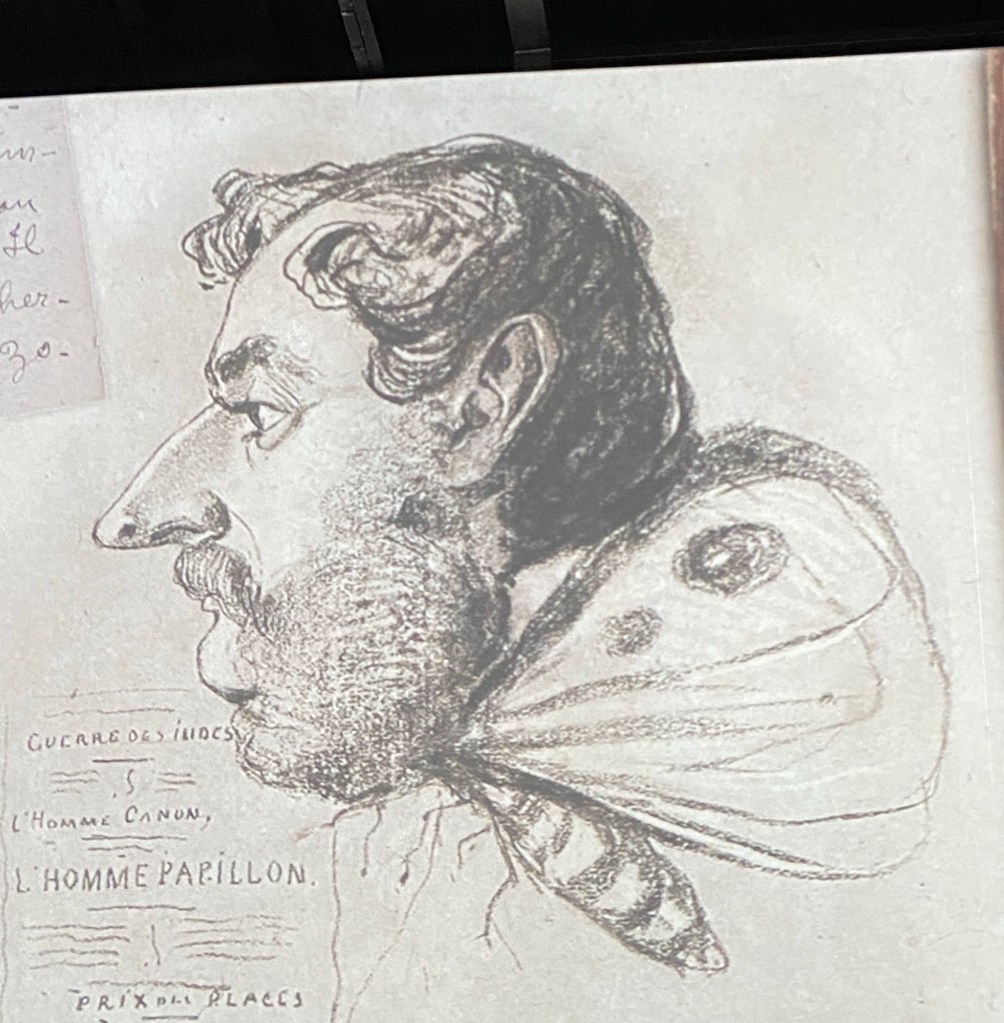 Karikaturskizze eines Mannes mit langer Nase und Backenbart, der auf einem Schmetterlingskörper angewachsen ist.